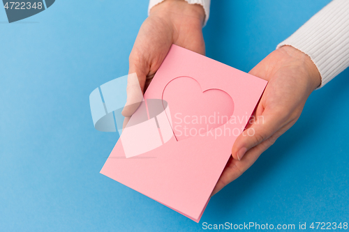 Image of hands holding greeting card with heart