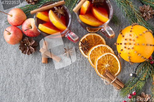 Image of glass of hot mulled wine, cookies, apples and fir