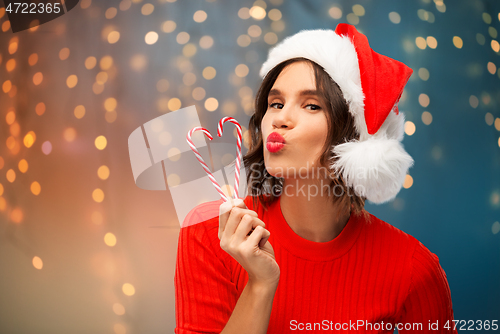 Image of happy young woman in santa hat on christmas