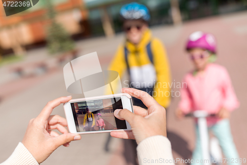 Image of hands with smartphone photographing school kids