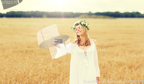 Image of happy young woman taking selfie by smartphone