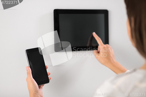 Image of woman using tablet computer and smartphone