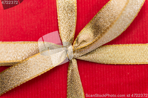 Image of close up of christmas red gift box with golden bow