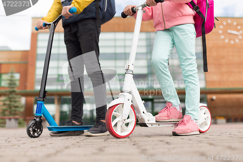 Image of school children with backpacks and scooters