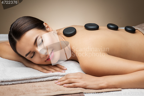 Image of woman having hot stone massage at spa