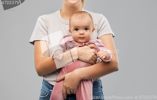 Image of happy young mother holding little baby daughter