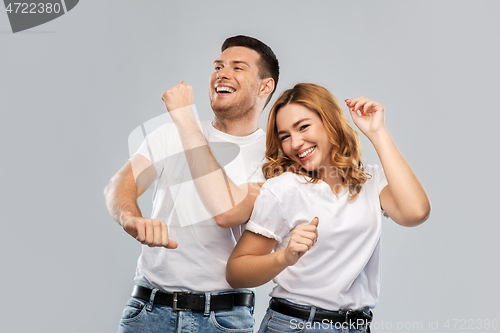 Image of portrait of happy couple in white t-shirts dancing