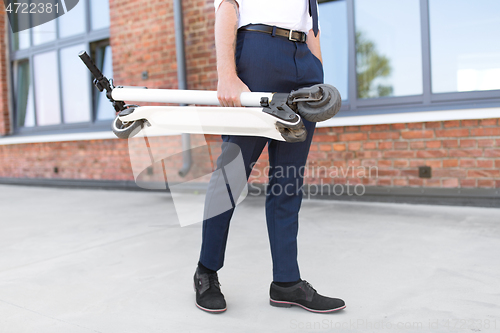 Image of businessman with folding scooter on rooftop