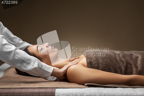 Image of woman having face and head massage at spa