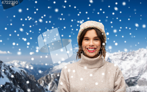 Image of young woman in knitted winter hat and sweater