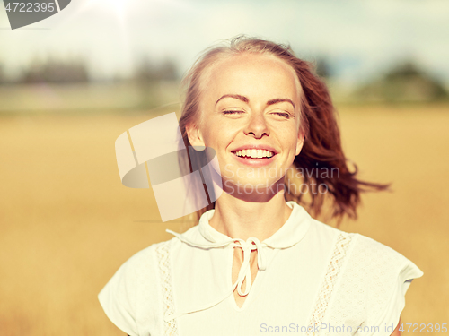 Image of smiling young woman in white on cereal field