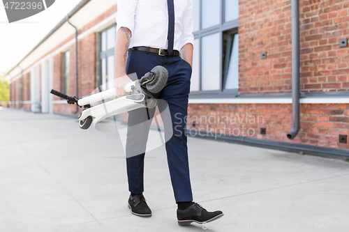 Image of businessman with folding scooter on rooftop
