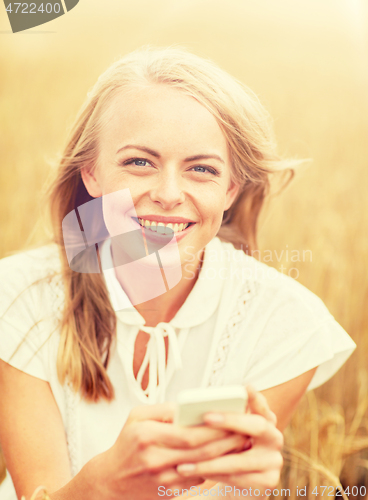 Image of happy woman with smartphone and earphones