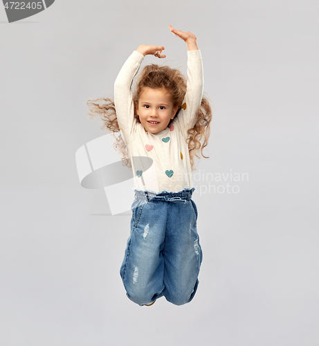 Image of smiling little girl jumping