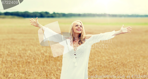 Image of smiling young woman in white dress on cereal field