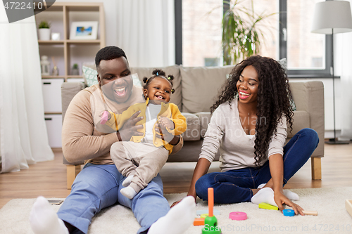 Image of african family playing with baby daughter at home