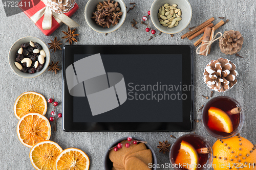 Image of tablet computer, mulled wine and christmas stuff