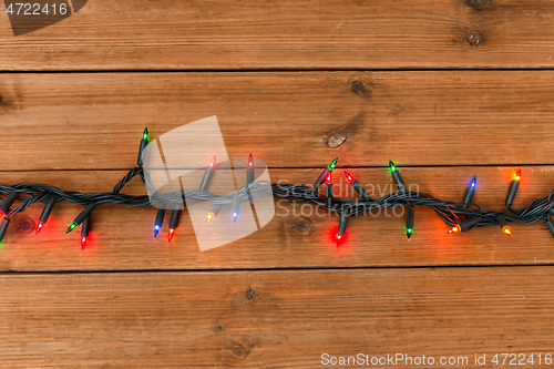 Image of christmas garland lights on wooden background