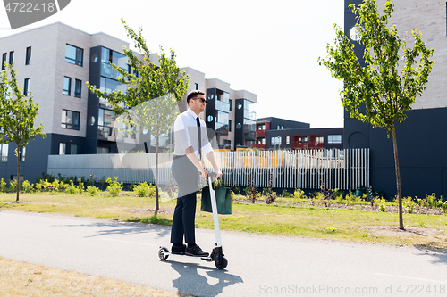 Image of businessman with shopping bag riding scooter