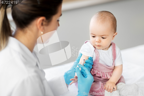 Image of doctor making vaccine for baby patient at clinic