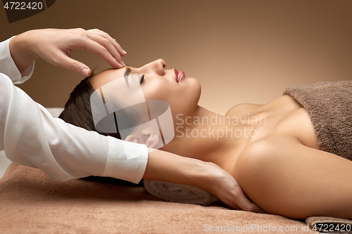 Image of woman having face and head massage at spa