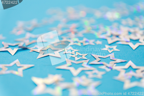 Image of star shaped confetti decoration on blue background