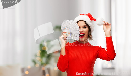 Image of happy woman in santa hat with money on christmas