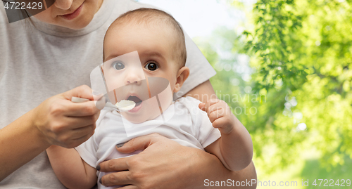 Image of close up of mother with spoon feeding little baby