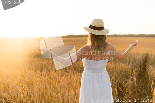 Image of happy woman in straw hat on cereal field in summer