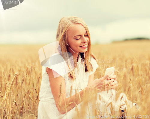 Image of happy woman with smartphone and earphones