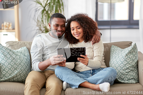 Image of african american couple with tablet pc at home