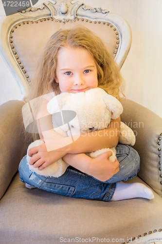 Image of Cute girl in casual clothes sitting in the armchair