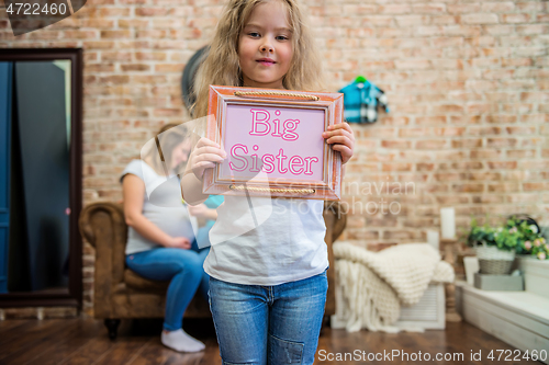 Image of Cute girl in casual clothes standing and holding a sign with text