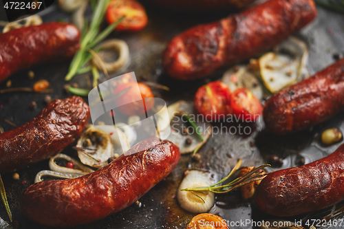 Image of Delicious grilled sausages served on metal rusty tray. With barbecued vegetables