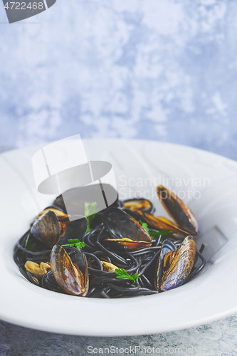 Image of Black seafood spaghetti pasta with mussels over stone background. Mediterranean delicious food