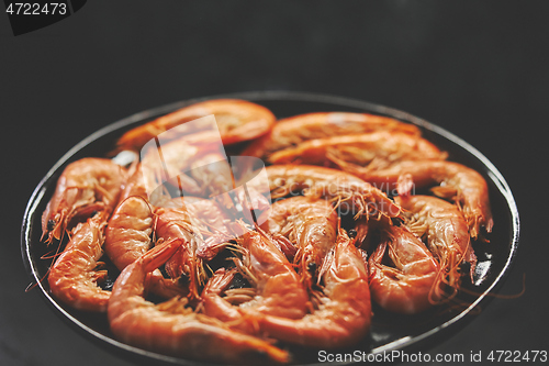 Image of Close up on boiled big sea prawns or shrimps placed on black ceramic plate