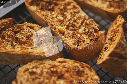 Image of Close up marcor shot of toasted baguette slices placed on grill frame. Top view