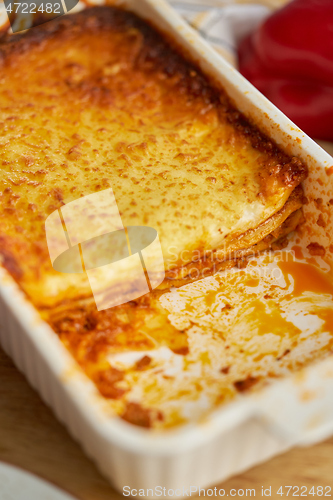 Image of Meat lasagna with tomato sause and melted cheese in white baking dish