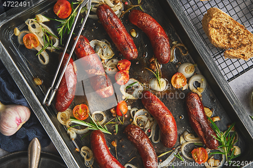 Image of Delicious grilled sausages served on metal rusty tray. With barbecued vegetables