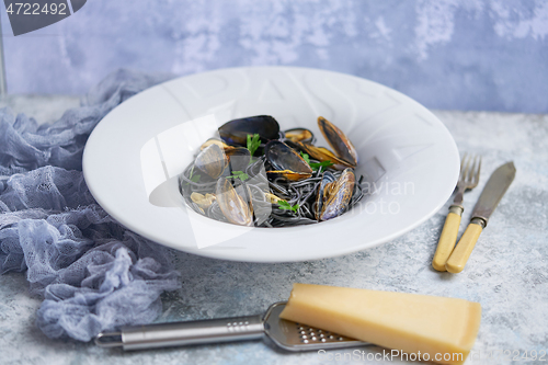 Image of Black seafood spaghetti pasta with mussels over stone background. Mediterranean delicious food