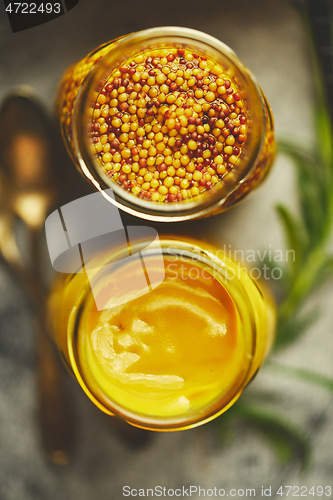 Image of Two kinds of mustard. Frensh with whole seeds and honey served in glass jars