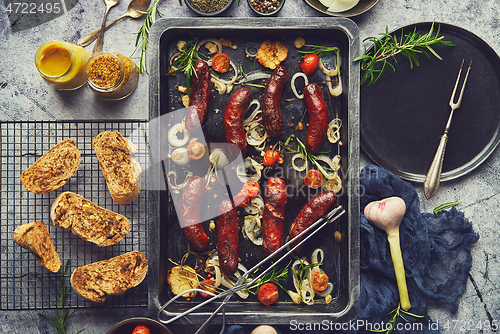 Image of Delicious grilled sausages served on metal rusty tray. With barbecued vegetables