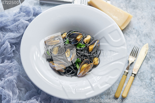 Image of Black seafood spaghetti pasta with mussels over stone background. Mediterranean delicious food