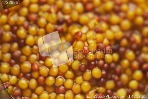 Image of French mustard with whole seeds served in glass jar. Selective focus