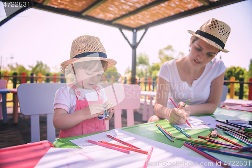 Image of mom and little daughter drawing a colorful pictures