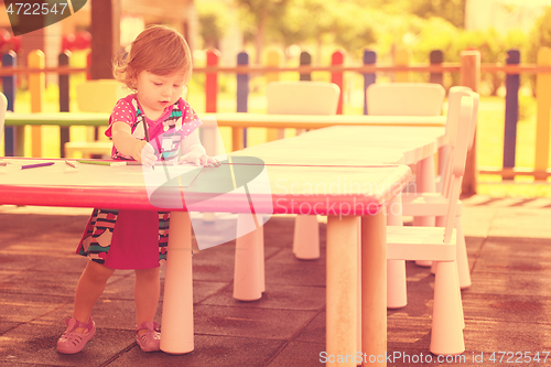 Image of little girl drawing a colorful pictures