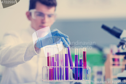 Image of student with protective glasses making chemistry experiment