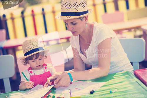 Image of mom and little daughter drawing a colorful pictures