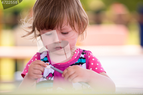 Image of little girl drawing a colorful pictures