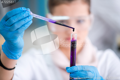 Image of female student with protective glasses making chemistry experime